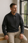 Männermodell trägt schwarzen Herrenpullover mit Polokragen – stilvoller Look in natürlicher Studio-Umgebung